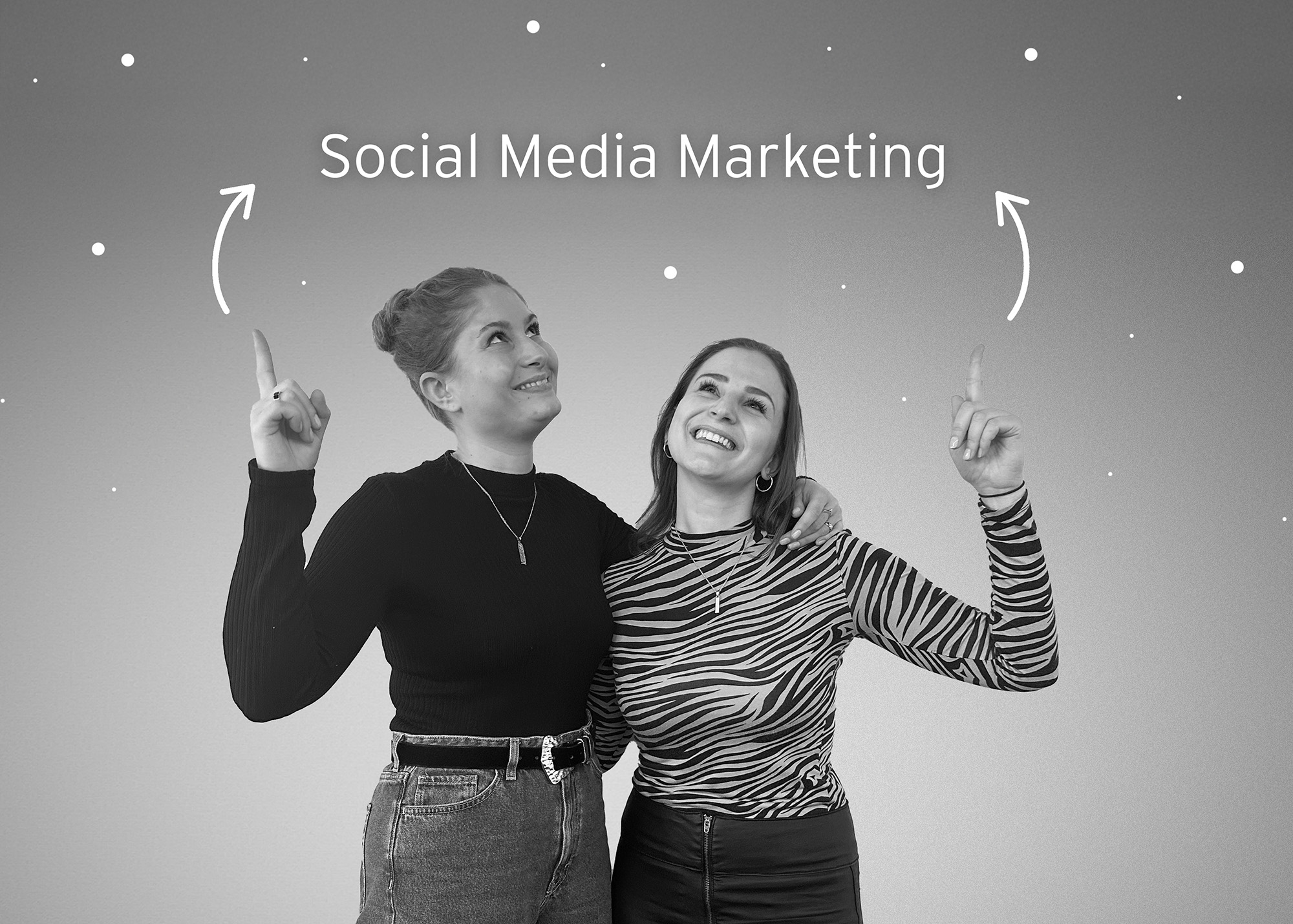 Foto von Anja und Melanie wie die nach oben zeigen auf "Social Media Marketing"