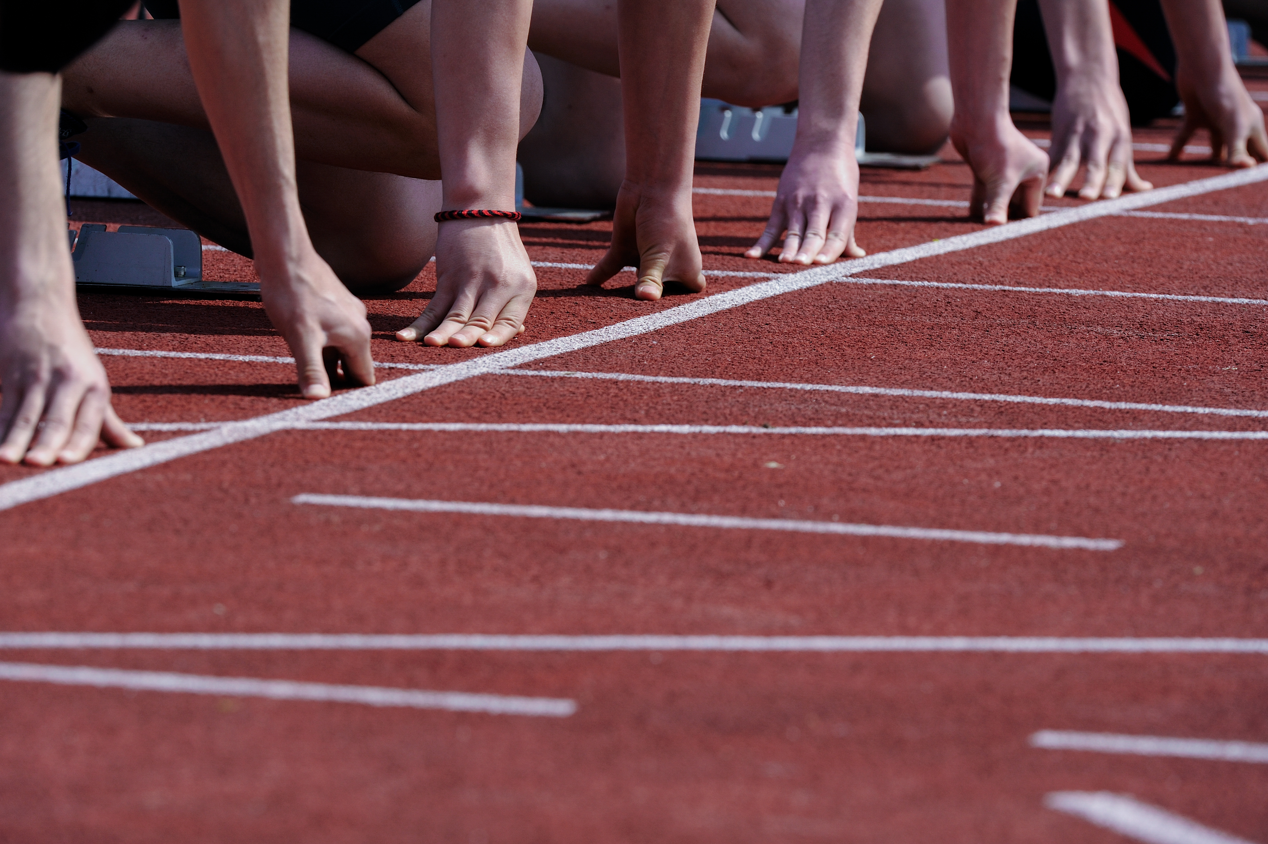 Foto Hände Läufer beim Start im Stadion | Projektmanagement IPMA & Anlaufmanagement