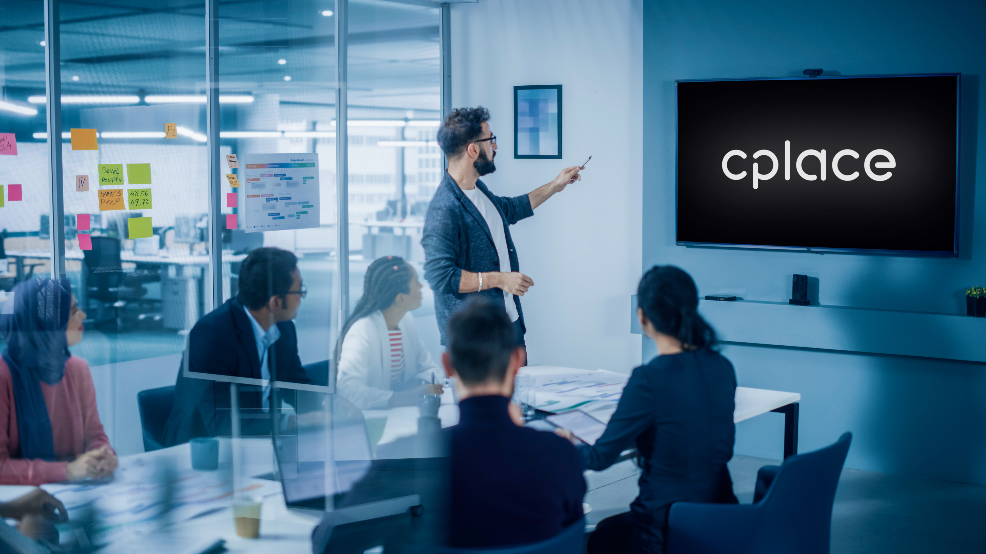 Foto eines Team Meetings im Konferenzraum, auf Bildschirm wird cplace-Logo angezeigt