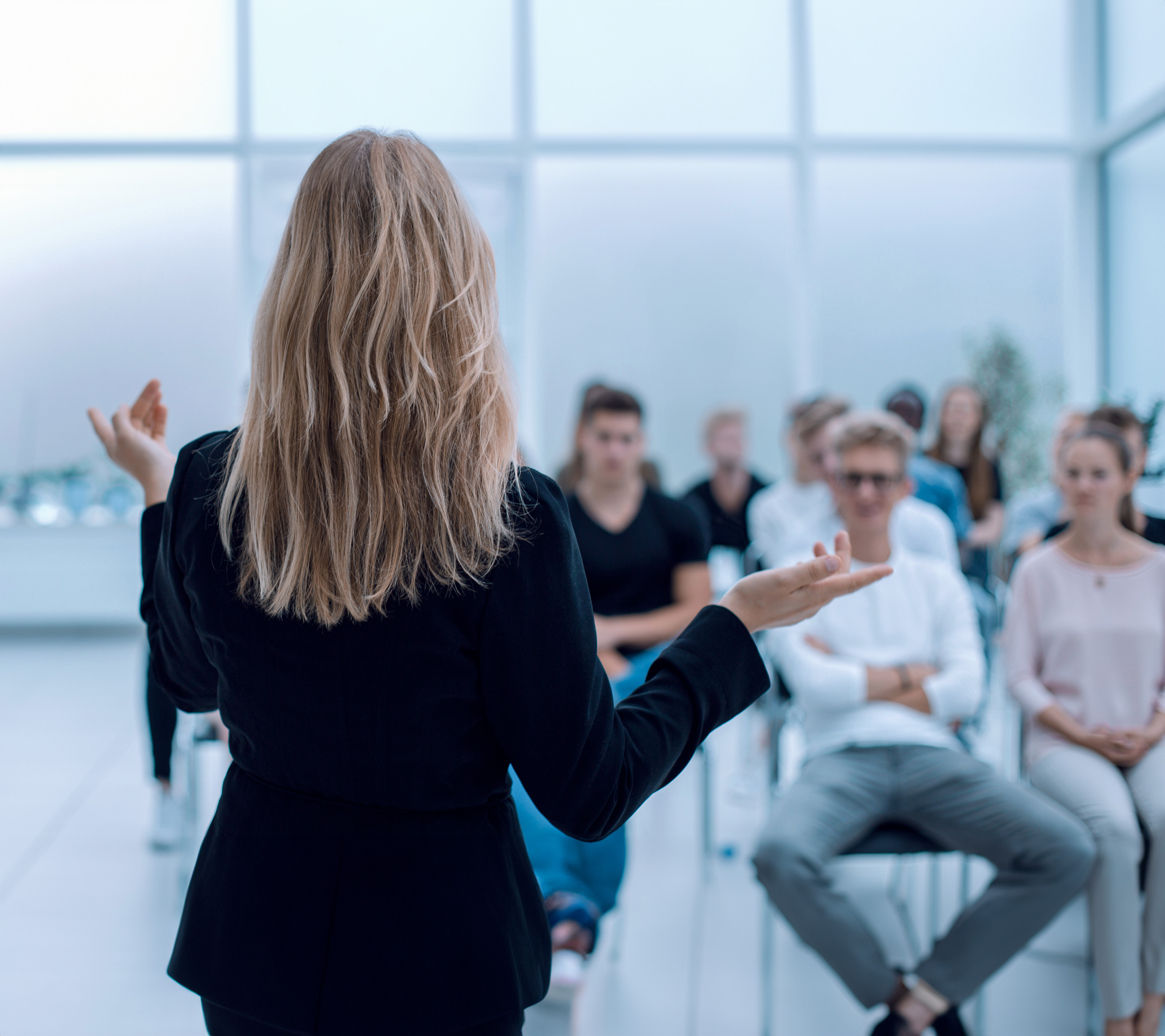 Foto aus dem Hintergrund eines Business Seminars in einem hellen Konferenzraum | Leadership, Radical Collaboration, Personalentwicklung, Managed Training Service