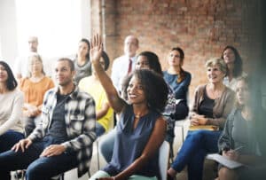 Foto einer Klasse im Sitzen, manche melden sich | Resilienz und Diversity